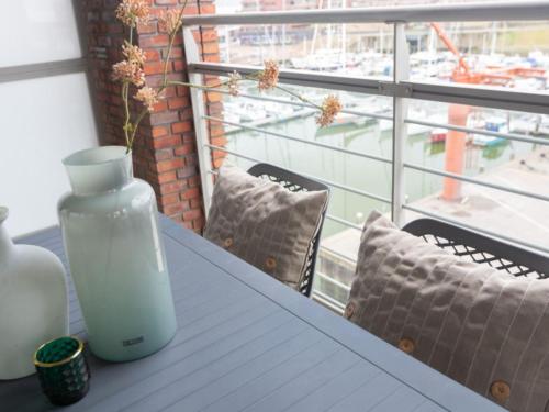 a vase on a table with a view of a harbor at Modern apartment close to the beach and the sea in Scheveningen