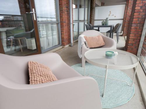 una sala de estar con 2 sofás blancos y una mesa. en Modern apartment close to the beach and the sea en Scheveningen