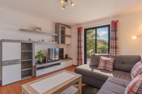 a living room with a couch and a tv at Villa Rosa with private pool by Holiday Rental Madeira in Ribeira Brava