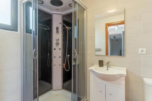 a bathroom with a shower and a sink at Villa Rosa with private pool by Holiday Rental Madeira in Ribeira Brava