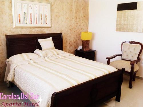 een slaapkamer met een bed en een stoel bij travis.apartments in La Viva