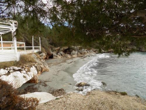 a beach with a white bench and the water at JERRY'S STUDIOS LASSI in Lassi