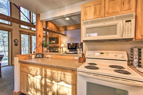 a kitchen with a stove and a microwave at Klamath Falls Cabin Retreat with Deck and Grill! in Klamath Falls