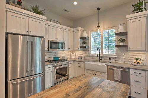 a kitchen with white cabinets and a stainless steel refrigerator at Modern Farmhouse with Patio, Grill and Mtn Views! in Ogden