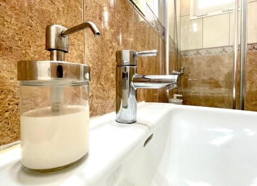 umywalkę w łazience z dozownikiem mydła w obiekcie Sea Soul Apartment Puerto Santiago w mieście Puerto de Santiago