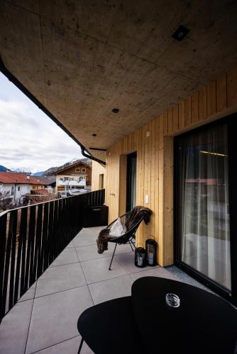a balcony of a house with a chair on it at Lebe`oetz - Das Ferienapartmenthaus im Zentrum von Oetz in Oetz