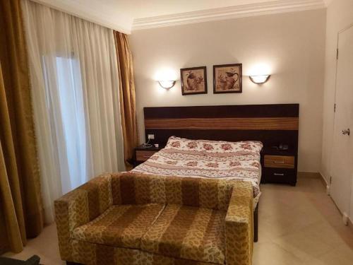 a bedroom with a bed and a couch in it at JWE Residence - Quality experience near Red Sea in Hurghada