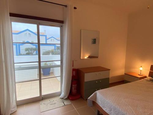 a bedroom with a bed and a large window at CASA NA COLINA - MORADIA com PISCINA in Tavira