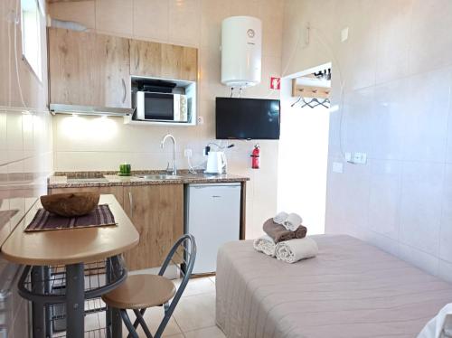 una pequeña cocina con una mesa pequeña y una pequeña cocina con una mesa pequeña en Casa Ponto de Encontro en Almodôvar