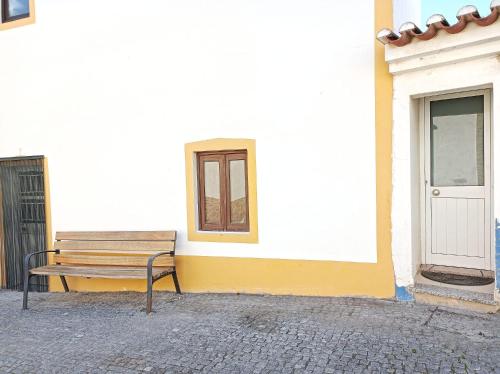 a bench sitting in front of a building at Casa Ponto de Encontro in Almodôvar