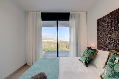 una camera con un letto e una grande finestra di 085 Modern Apartment in Trendy La Cala Golf Resort a Málaga