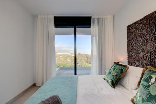 1 dormitorio con cama y ventana grande en 085 Modern Apartment in Trendy La Cala Golf Resort, en Málaga