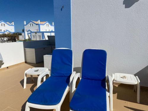two blue chairs and a table on a balcony at CASA NA COLINA - MORADIA com PISCINA in Tavira