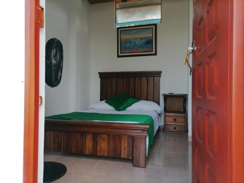 a bedroom with a bed and a red door at Hotel campestre la Maria in Villavicencio