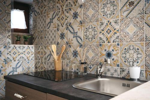 a kitchen with a sink and a tile wall at Dimora Santa Caterina in Altamura