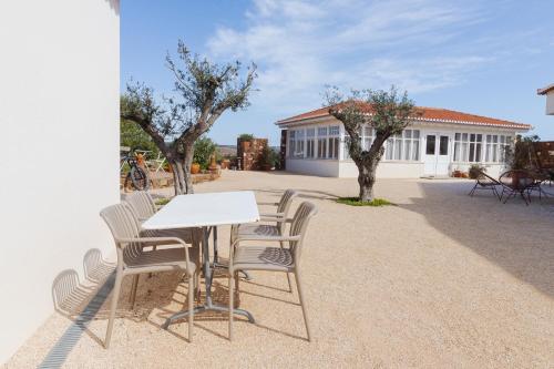 a white table and chairs in front of a house at Moinho Calmo in Vila do Bispo
