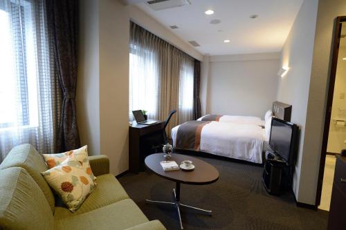 Una cama o camas en una habitación de Natural Hot Spring Midosuji Hotel