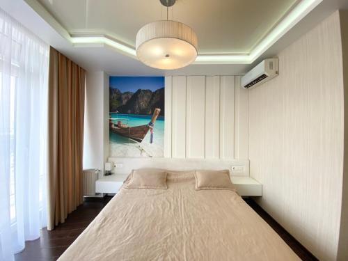 1 dormitorio con 1 cama con una pintura en la pared en Most City Center Studio Apartment en Dnipro