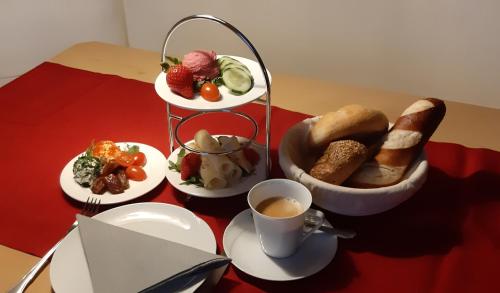 a table with plates of food and a cup of coffee at Gästehaus Huber in Mittersill