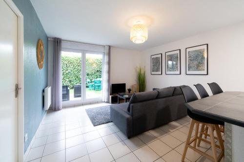 un salon avec un canapé et une table dans l'établissement My Cozy Flat Blagnac - T2 - Free Parking - Terrasse - Jardin, à Blagnac