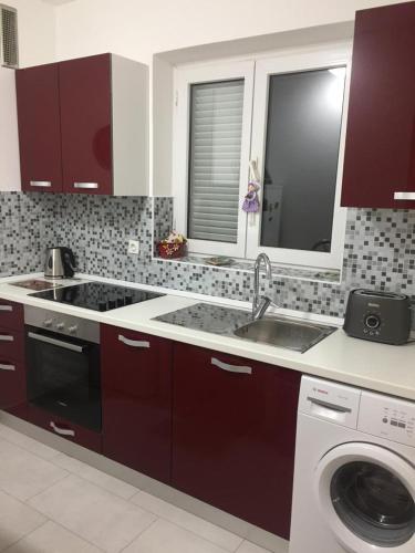 a kitchen with a sink and a washing machine at Apartmani Selce in Selce