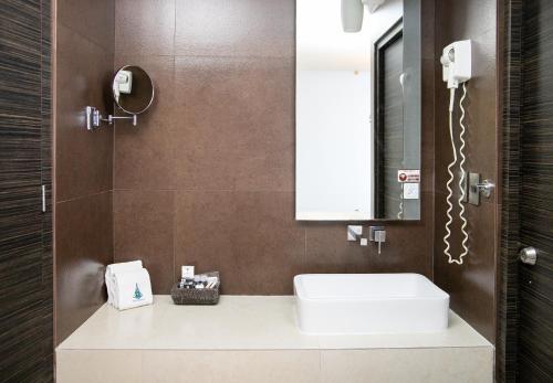 łazienka z białą umywalką i lustrem w obiekcie Hotel Brasilia w mieście Meksyk