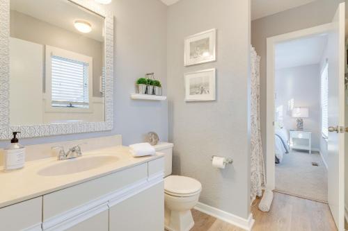 a bathroom with a sink and a toilet and a mirror at Sounds Great! in Duck