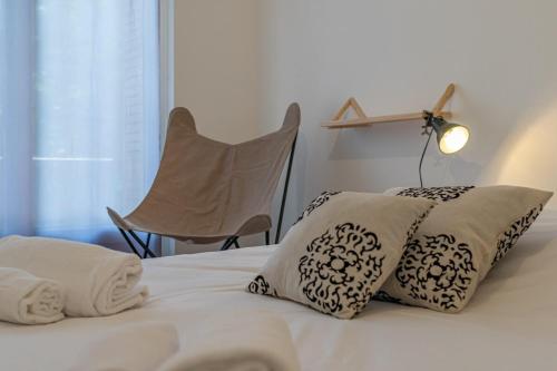 een bed met 2 kussens en een lamp en een stoel bij Apartment with balcony in the city center in Annecy