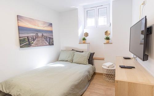 a bedroom with a bed and a desk with a tv at Belem Studio - Near Main Touristic Area in Lisbon