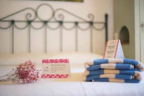 a bed with a bunch of towels on a bed at Hotel Rural Biniarroca - Adults Only in Sant Lluis