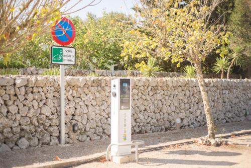 a street sign next to a rock wall at Hotel Rural Biniarroca - Adults Only in Sant Lluis