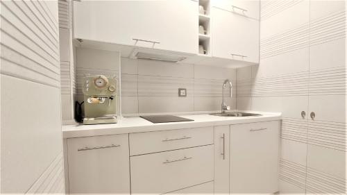 a white kitchen with white cabinets and a sink at Apartamento San Nicolás - tranquilidad y comodidad en el centro de Murcia in Murcia