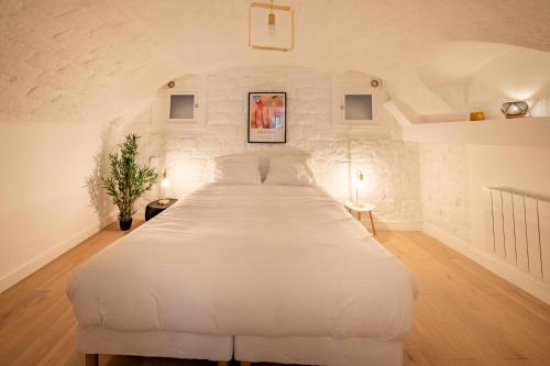une chambre avec un grand lit blanc dans une pièce dans l'établissement APPARTEMENT CONTEMPORAIN RÉPUBLIQUE - TEMPLE 2, à Paris