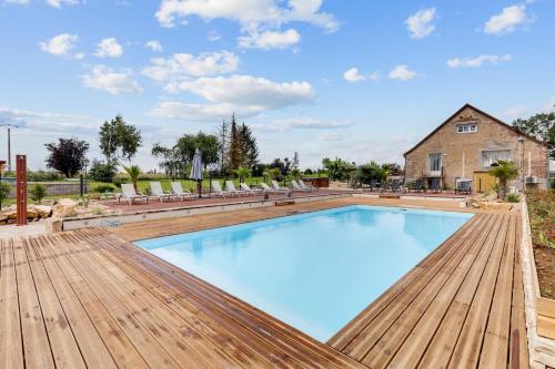 une grande piscine avec terrasse en bois et une maison dans l'établissement Le Moulin d'Hauterive, à Saint-Gervais-en-Vallière
