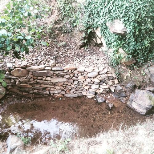 a dry stone wall on the side of a field at Casa Rural El Arroyo in Sotoserrano