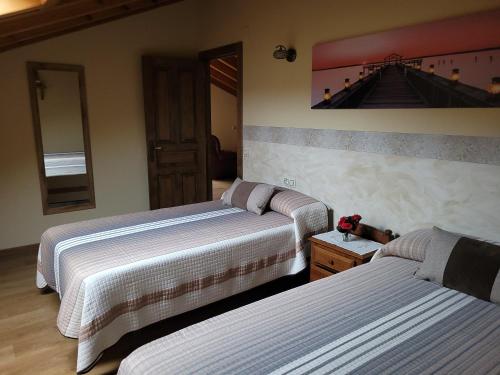 una habitación de hotel con 2 camas y un cuadro en la pared en El Cameliar - Vibañu, en Vibaño