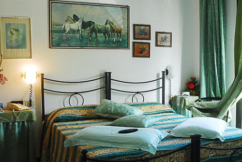 a bedroom with a bed with a picture of horses on the wall at Hotel Ebe in San Piero a Sieve