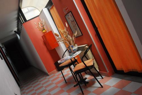 a table and two chairs in a room with orange walls at Hotel Ebe in San Piero a Sieve
