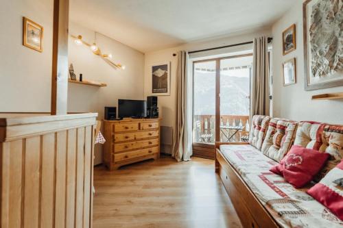 a living room with a couch and a television at Furnished studio at the foot of the slopes with a balcony & mountains view in Saint-Gervais-les-Bains