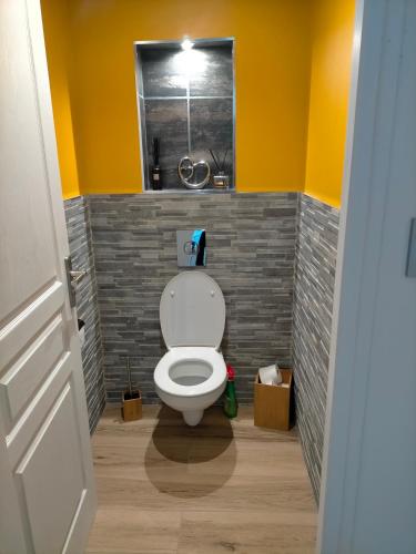 uma casa de banho com WC num quarto com paredes amarelas em Chez Michele et Jean Louis em Pignans