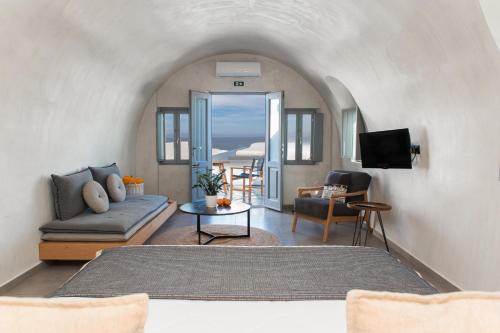 ein Wohnzimmer mit einem Sofa und einem Tisch in der Unterkunft Almyra Oia Suites in Oia