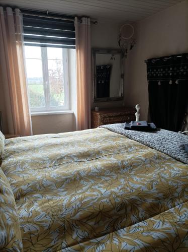 a bedroom with a large bed with a large window at Le Breil Furet in Ménéac