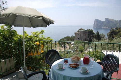 a table with food and an umbrella on a balcony at Villaggio Residence Nettuno in Massa Lubrense