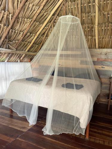 a bed covered in a net in a room at Chavez Eco Beach Camping and Cabañas in Tulum