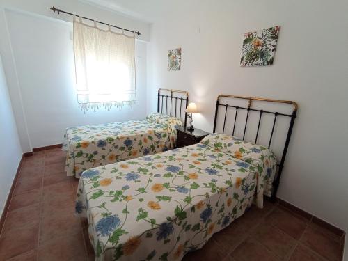 2 camas individuais num quarto com uma janela em EL RINCÓN DE BLASA em Cazorla