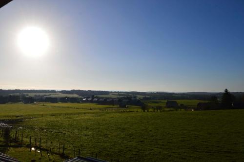 a green field with the sun in the sky at Villa Cambo in Grandhan