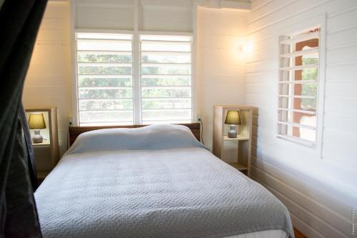 a small bedroom with a bed and a window at Horse Cottage in Sarteneja