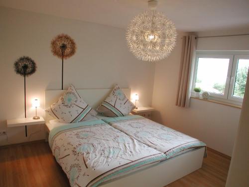 Un dormitorio con una cama grande y una lámpara de araña. en Ferienwohnung Pusteblume, en Cochem