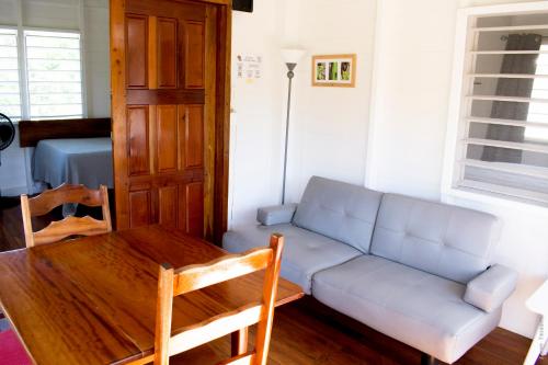 a living room with a couch and a table at Horse Cottage in Sarteneja