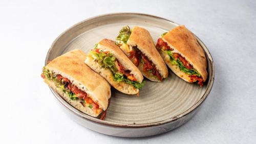 três sanduíches num prato numa mesa em Corso Rooms City Centre em Novi Sad